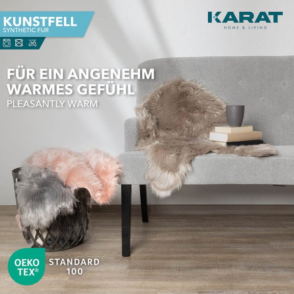 Kunstfell-Teppiche auf Sofa und in Korb im hellen Wohnzimmer, schadstoffgeprüft nach Oeko-Tex Standard 100, Karat Home & Living Logo.