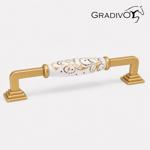 Möbelgriff aus goldfarbenem Metall und weißer Keramik mit Ornamentmuster. Gradivo Logo.