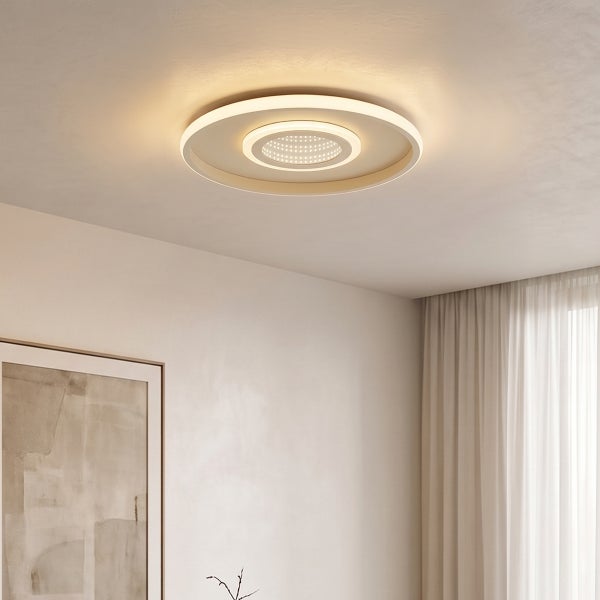 Moderne runde LED Deckenleuchte mit zwei Lichtringen in einem hellen Wohnraum.
