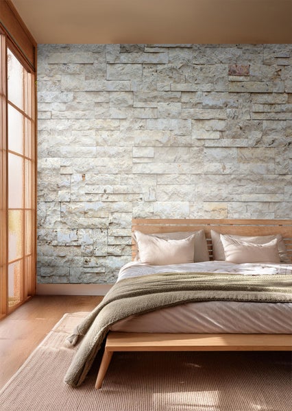 Heller Schlafraum mit Steinwand