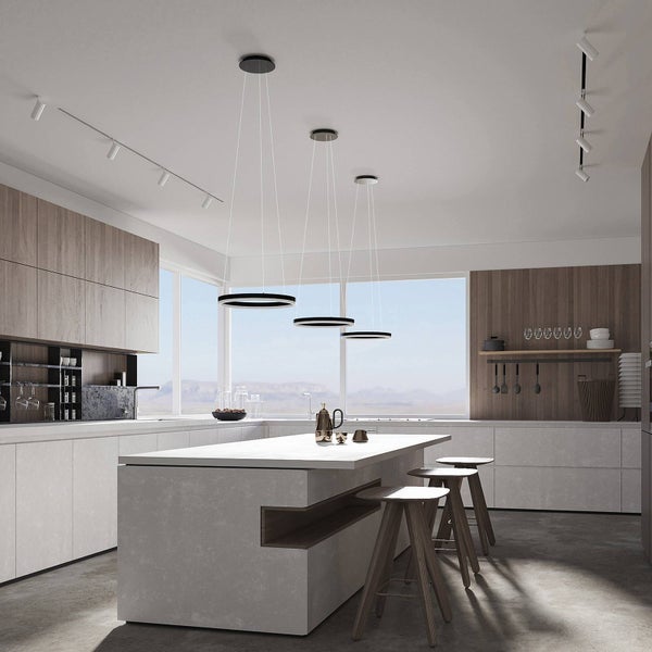 Moderne helle Küche mit Kochinsel in Steinoptik, drei ringförmigen Pendelleuchten, Holzbarhockern und Schränken in Holzoptik.