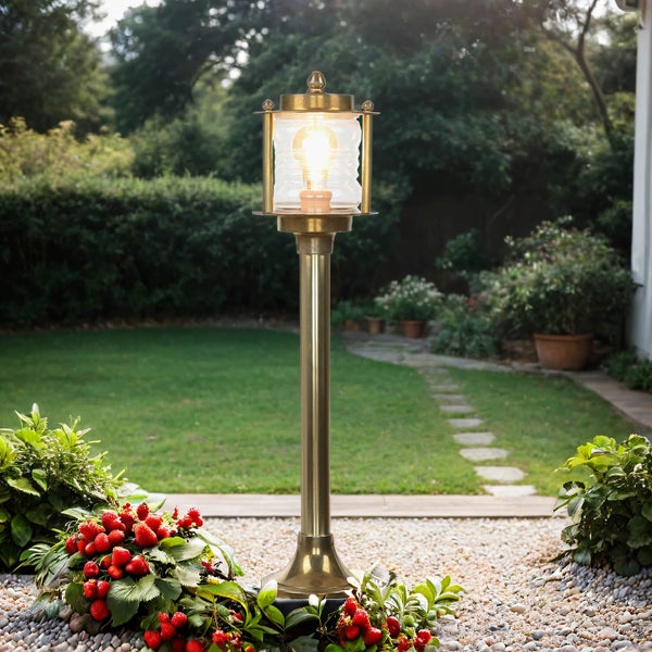 Gartenlaterne aus Metall mit klarem Lampenschirm in einem Garten