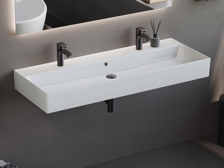 Waschtisch mit zwei Armaturen in einem Badezimmer.