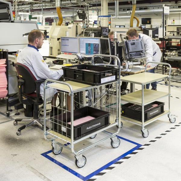 Industrieanlage mit Mitarbeitern und Rollwagen