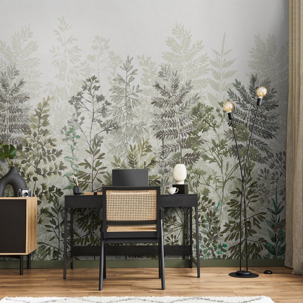Einrichtung eines Arbeitszimmers mit Schreibtisch, Stuhl, Stehlampe, Kommode und einer Tapete mit Pflanzenmotiven