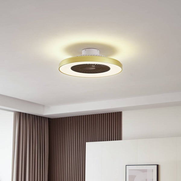 Moderner Deckenventilator mit LED-Lichtring in Gold-Optik, montiert an der Decke in einem hellen Zimmer mit Holzlamellenwand und Vorhängen.