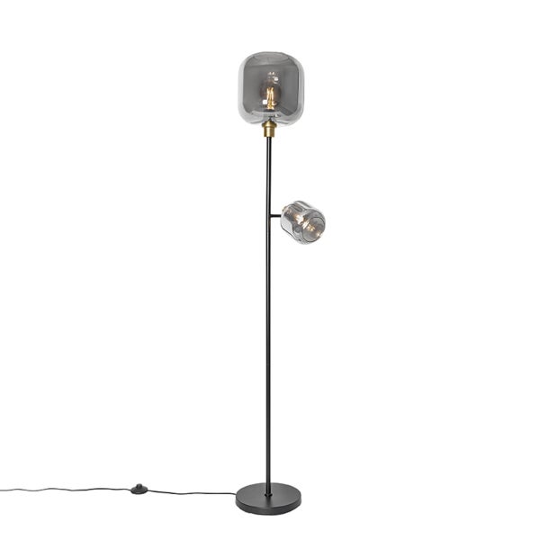 Moderne Stehleuchte mit zwei Lichtquellen, schwarzem Metallgestell, rundem Standfuß und rauchgrauen Glasschirmen mit Messingakzenten.