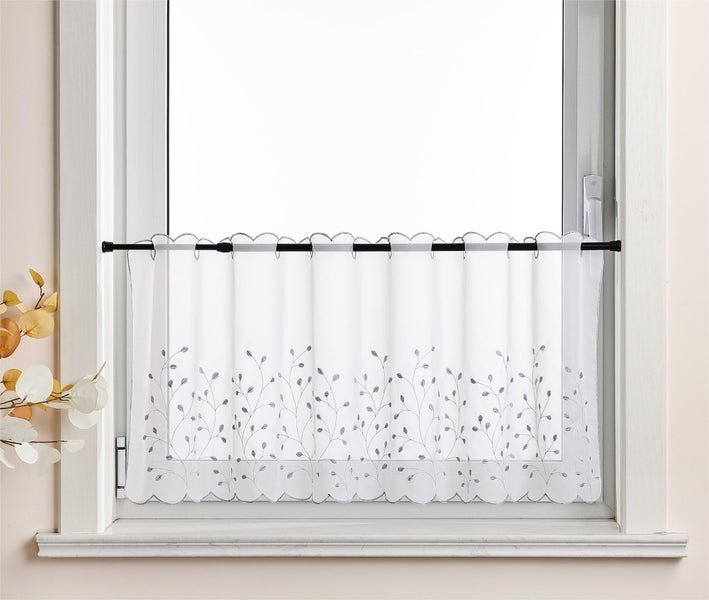 Gardine mit Blätterrankenmuster vor einem Fenster