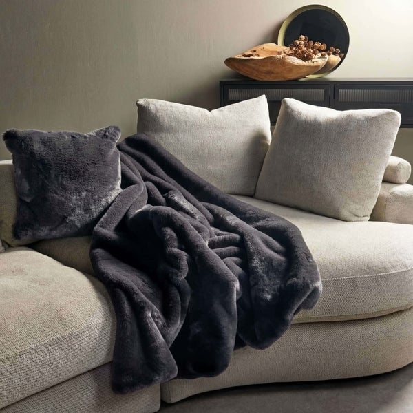 Dekoratives Wohnzimmer mit Sofa, Kissen und Tagesdecke