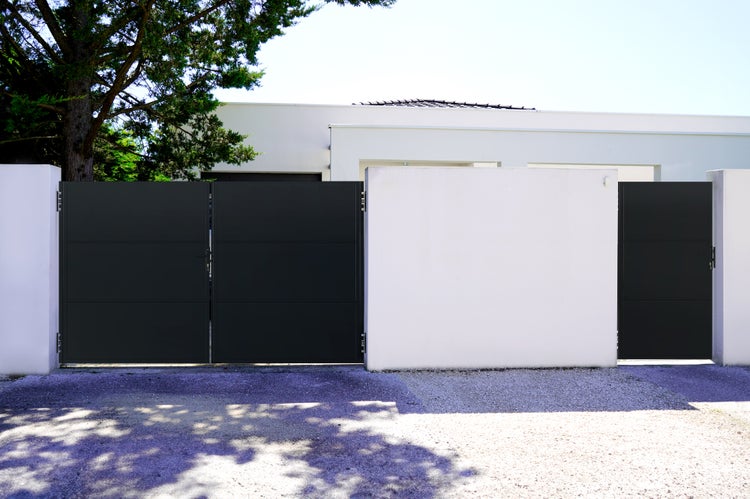 Modernes Haus mit schwarzem Tor und weißer Mauer