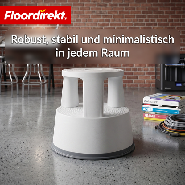 Floordirekt Logo. Ein weißer Rollhocker aus Kunststoff auf einem grauen Betonboden in einem hellen Raum mit Ziegelwand im Industriedesign.