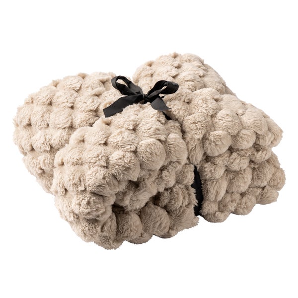 Beige, gefaltete Kuscheldecke mit Noppenstruktur aus weichem Kunstfell, mit schwarzem Band gebunden.