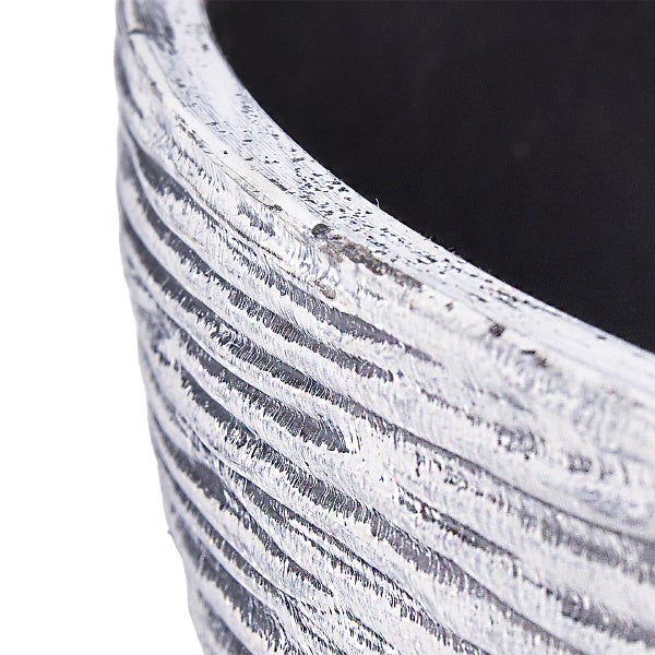 Detailansicht eines Pflanzkübels mit horizontaler Rillenstruktur und patinierter Oberfläche.