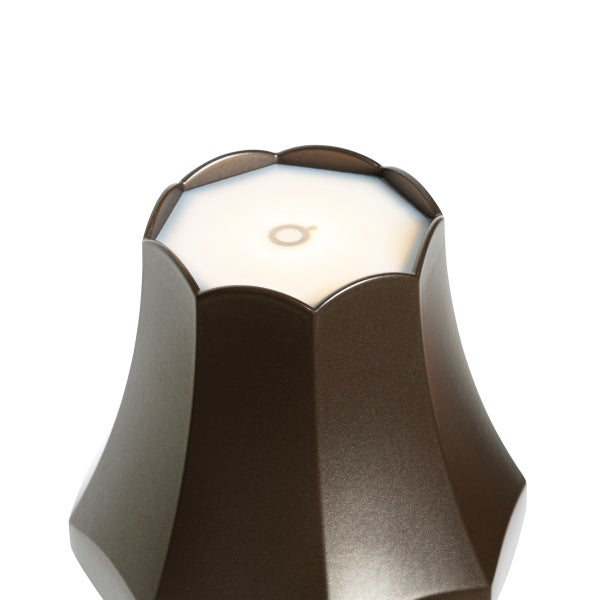 Nahaufnahme der Oberseite einer bronzefarbenen LED-Akkuleuchte mit blütenförmigem Rand, weißer Leuchtfläche und Touch-Symbol.