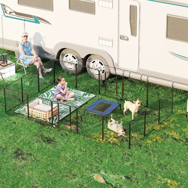 Mobiler Welpenauslauf aus Metall auf Rasen neben einem Wohnmobil. Im Gehege sind zwei Hunde, ein Kind, ein Hundebett und eine Hundeliege.