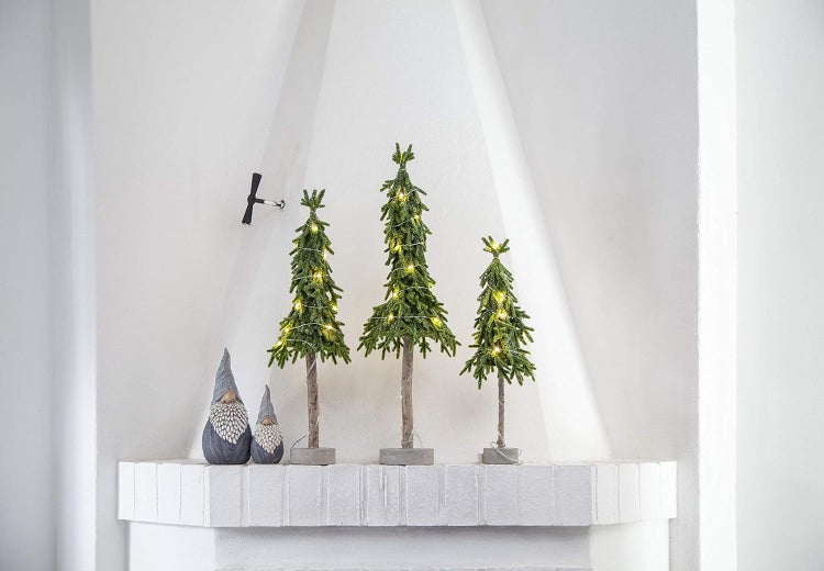 Dekorative Szene mit drei beleuchteten Weihnachtsbäumen und zwei Zwergenfiguren