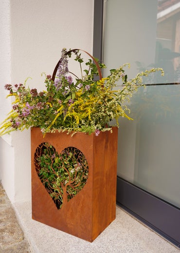 Künstliche Studentenblume mit großer orange-gelber Blüte, grünem Stiel und gezackten Blättern.