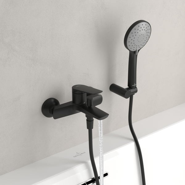 Schwarze Badewannenarmatur mit Handbrause an einer Wand montiert