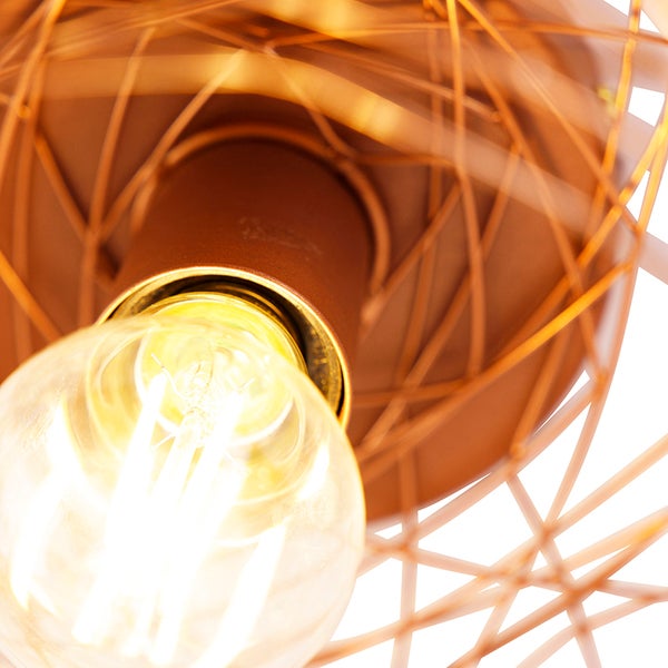 Nahaufnahme einer leuchtenden Glühbirne in einer Drahtleuchte