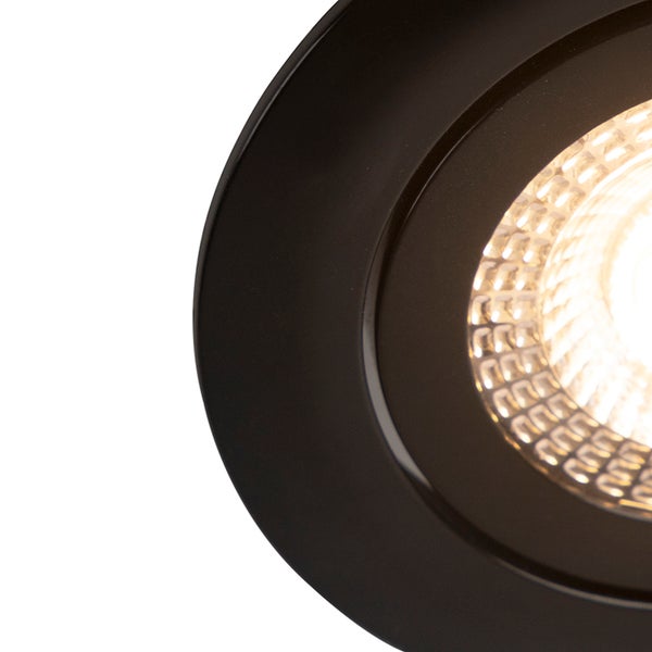 Nahaufnahme eines runden LED-Einbaustrahlers mit schwarzem Rahmen und eingeschaltetem Leuchtmittel.