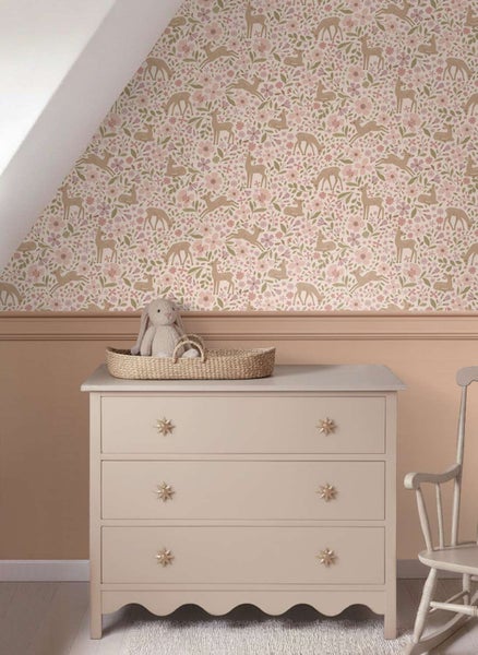 Kindertapete mit Waldmotiv und Hirschen an einer mit Holzpaneelen abgesetzten Wand in einem Kinderzimmer mit Kommode.