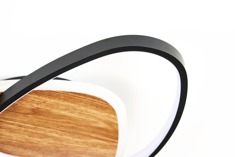 Detail einer modernen LED-Deckenleuchte in Holzoptik mit geschwungenem schwarzem Metallrahmen.