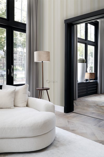 Helles Wohnzimmer mit Sofa, Stehlampe und gestreifter Tapete