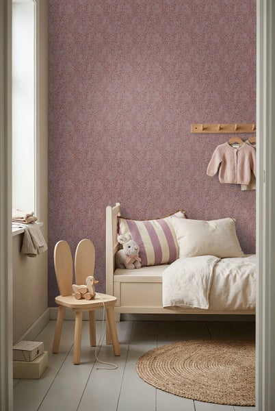 Gemütliches Kinderzimmer mit floral gemusterter Tapete, hellem Holzbett, Hasen-Stuhl und rundem Jute-Teppich im skandinavischen Stil.