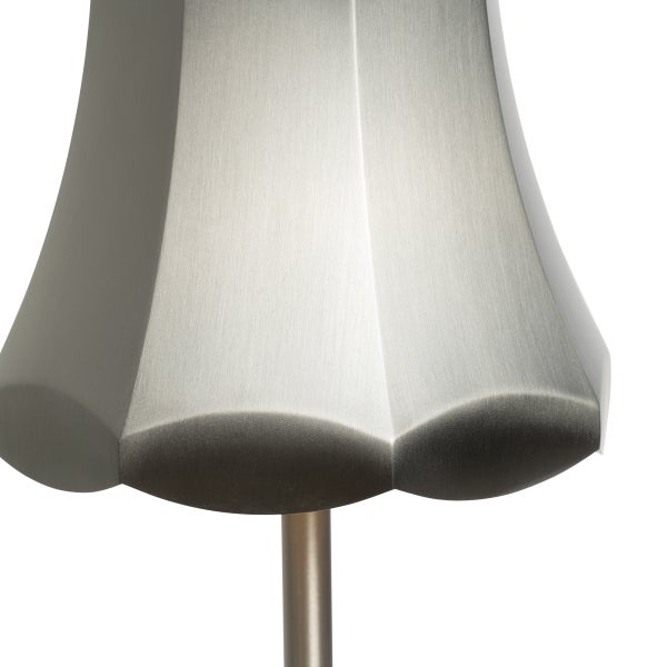 Nahaufnahme eines Lampenkopfes aus gebürstetem Metall mit facettiertem, wellenförmigem Design.