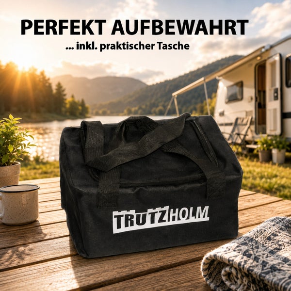 Trutzholm Tragetasche für Camping und Outdoor auf einem Holztisch vor einem Wohnwagen am See.