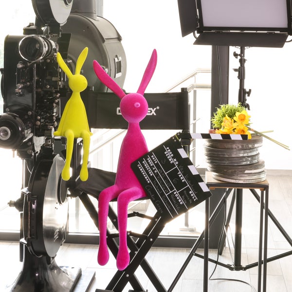 Dekorative Filmrequisiten mit Filmprojektor, Filmklappe, Filmrollen und Deko-Hasen