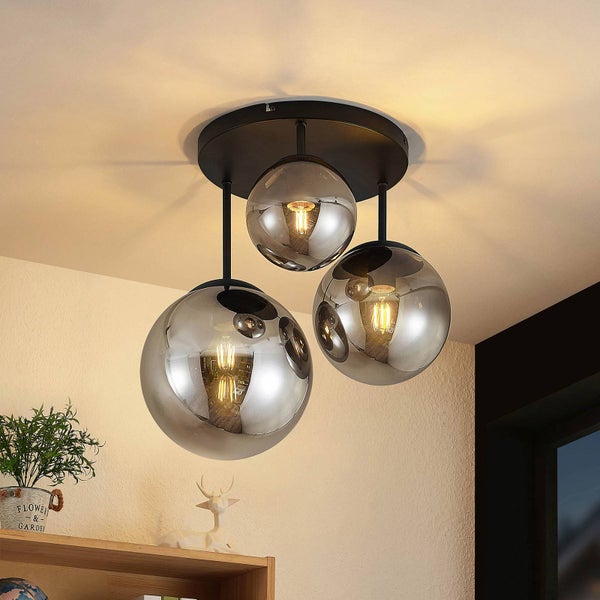 Dreiflammige Deckenleuchte mit drei verspiegelten Glaskugeln in verschiedenen Größen und schwarzer Halterung in einem hellen modernen Wohnraum.