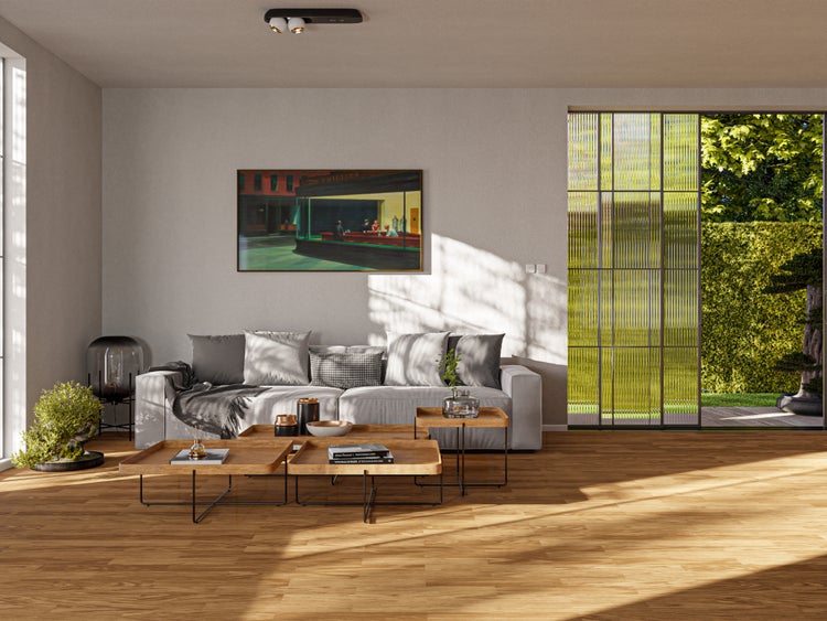 Modernes Wohnzimmer mit Parkett in Eichenoptik, grauem Sofa, Holztischen und großer Fensterfront zum Garten.