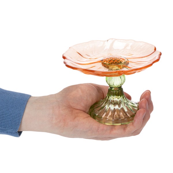 Hand hält eine dekorative Glasschale in Blütenform