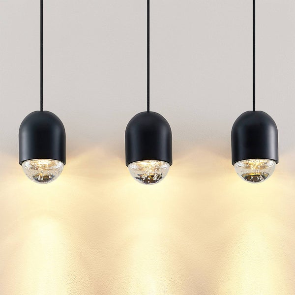 Drei moderne Pendelleuchten mit schwarzen Lampenschirmen und Glaskugeln