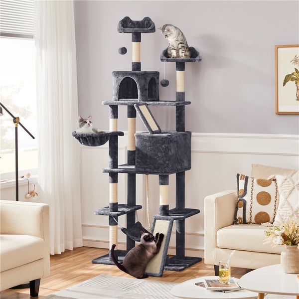 Katzenkratzbaum mit mehreren Ebenen, Höhlen und Liegeflächen in einem Wohnzimmer mit drei Katzen