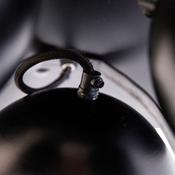 Detailaufnahme einer schwarzen Pendelleuchte mit Textilkabel