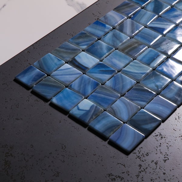 Nahaufnahme eines Schwimmbeckens mit Mosaikfliesen und Treppe unter Wasser. Im Hintergrund tropische Pflanzen und der Schriftzug Betsan.