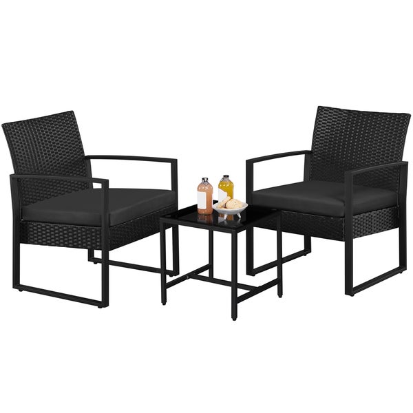 Gartenmöbelset mit zwei Rattansesseln, schwarzen Sitzkissen und einem Tisch mit Glasplatte