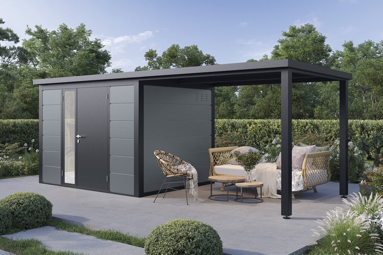 Modernes Gartenhaus aus Metall mit seitlichem Anbau und Terrasse inklusive Lounge Möbeln in einem Garten.