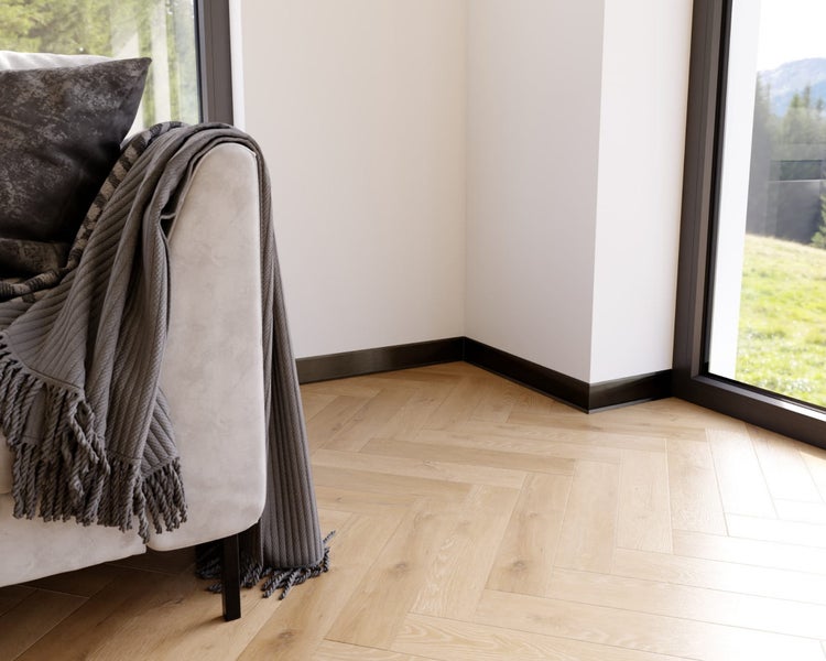 Innenraumszene mit Sofa, Kissen, Decke, Fußleisten und Holzboden