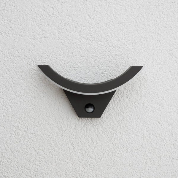 Moderne LED-Außenwandleuchte in Anthrazit mit geschwungener Form und integriertem Bewegungsmelder.