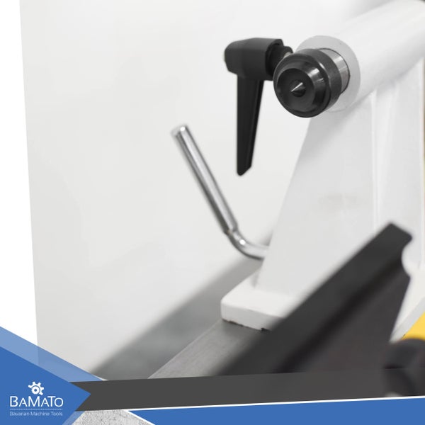 Detailansicht einer Drechselbank mit schwarzem Bedienelement und silberner Stange