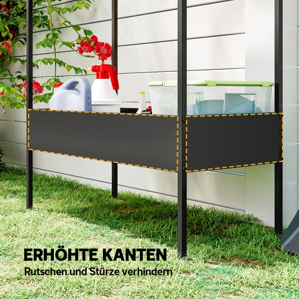 Gartentisch aus Metall in Schwarz mit erhöhten Kanten zur sicheren Aufbewahrung von Gartenutensilien, auf Rasen vor einer Wand.