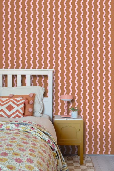 Schlafzimmer mit Bett, Nachttisch und brauner Tapete mit Wellenmuster