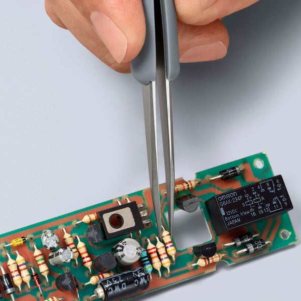 Pinzette auf einer elektronischen Platine zur Reparatur oder Wartung