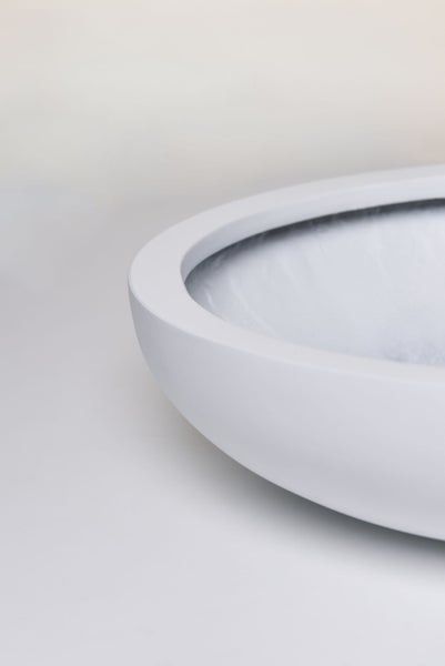 Detailaufnahme des Randes einer spülrandlosen Toilette aus weißer Keramik mit matter Oberfläche.