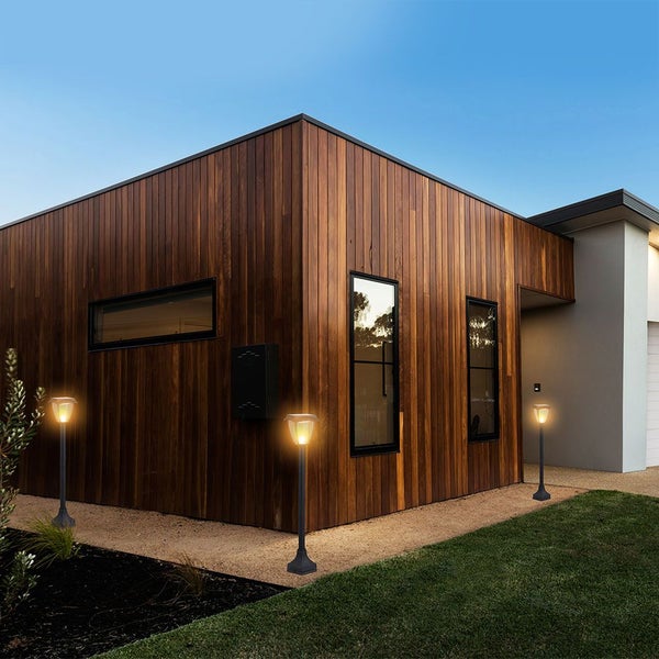 Außenansicht eines modernen Hauses mit Solarleuchten entlang des Gehwegs.