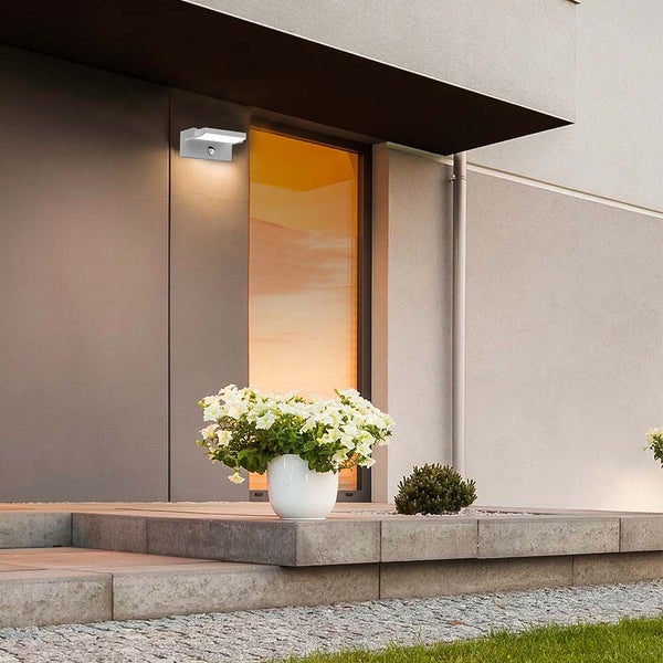 Moderne Hausfassade mit Außenlampe und Blumenarrangement