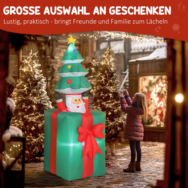 Aufblasbare Weihnachtsfigur Weihnachtsmann in Geschenkbox mit Tannenbaum, Kind fotografiert Dekoration auf festlichem Weihnachtsmarkt.